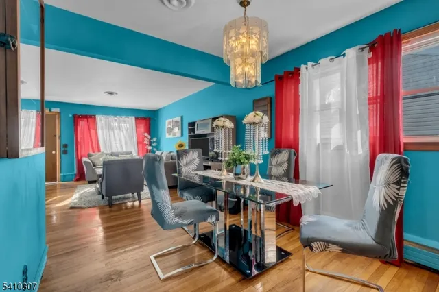 a view of a dining room with furniture a chandelier and wooden floor