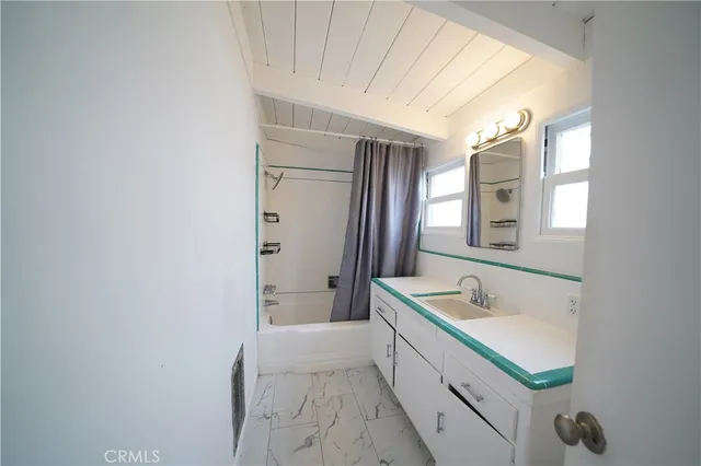 a bathroom with a sink a mirror and a bathtub