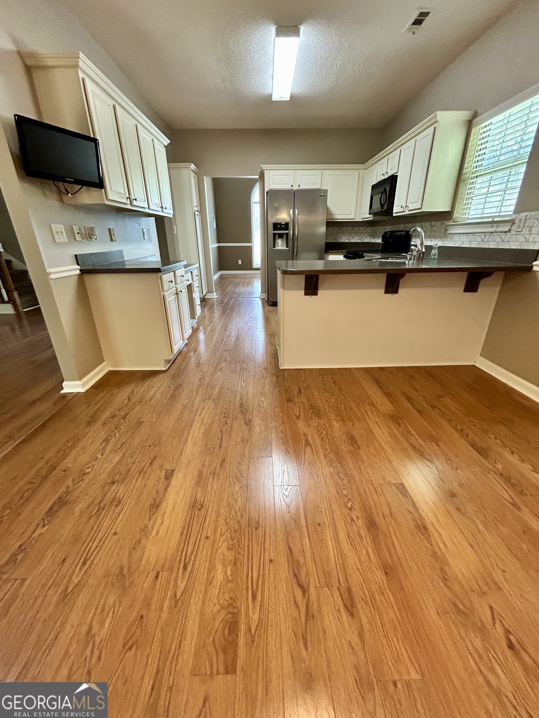 98 Pheasant Ridge Newnan, GA 30265 - Photo 8 of 23 a kitchen with stainless steel appliances wooden floors and wooden cabinets