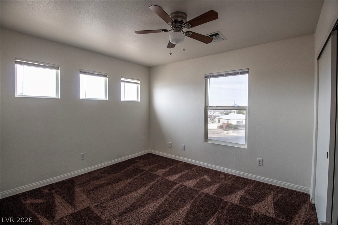 119 West Victory Road Henderson, NV 89015 - Photo 17 of 26 A comfortable bedroom with plush carpet and ample natural light through multiple windows.