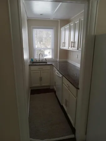 a kitchen with granite countertop white cabinets and white appliances