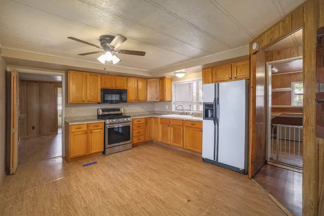 a view of a livingroom with a chandelier fan and windows