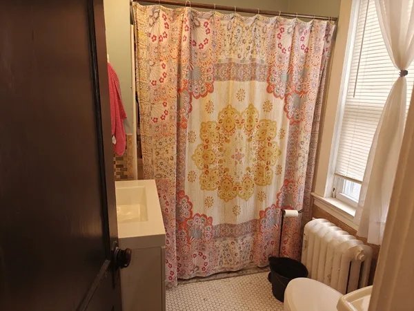 a view of bathroom with shower and curtain