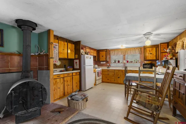 a kitchen with furniture a refrigerator and chairs