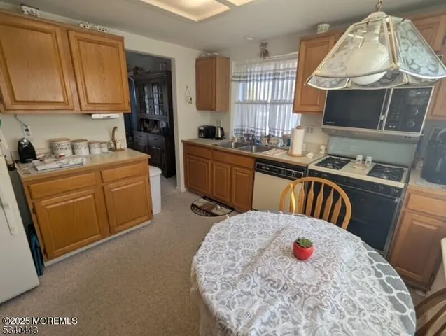 a kitchen with a sink a stove and a microwave