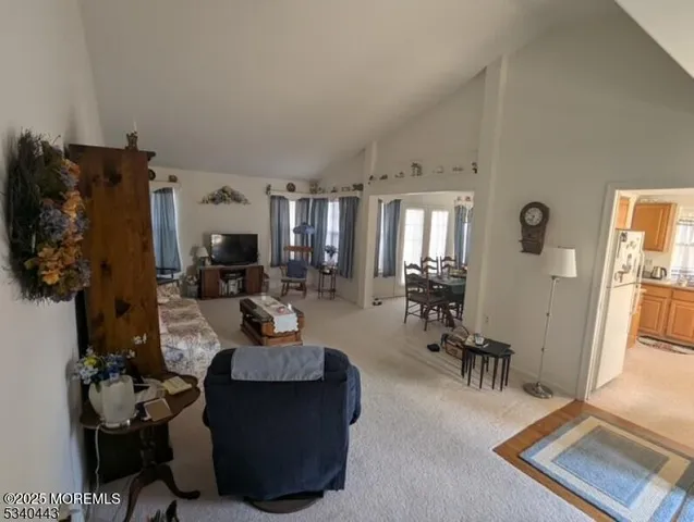 a living room with furniture and a large mirror next to a window