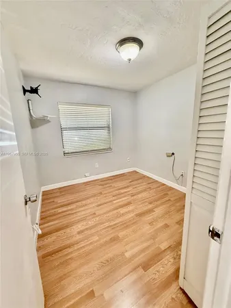 a view of a room with wooden floor and cabinet