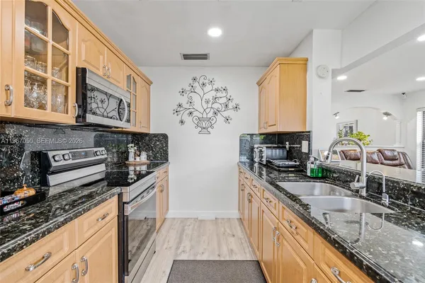 a kitchen with stainless steel appliances granite countertop a sink stove and refrigerator