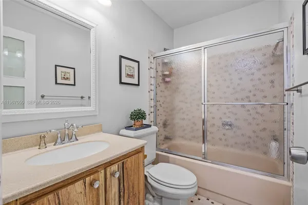 a bathroom with a granite countertop sink toilet and shower