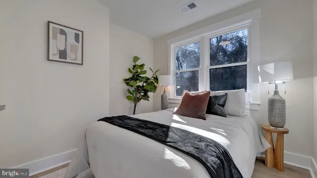 a bedroom with a bed and a potted plant
