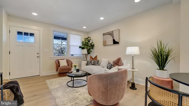 a living room with furniture a potted plant and white walls