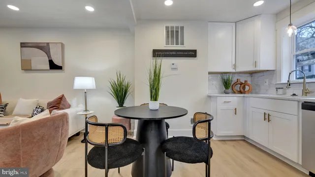 a kitchen with stainless steel appliances a table and chairs in it