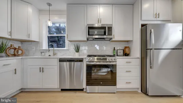 a kitchen with stainless steel appliances granite countertop a refrigerator stove and sink