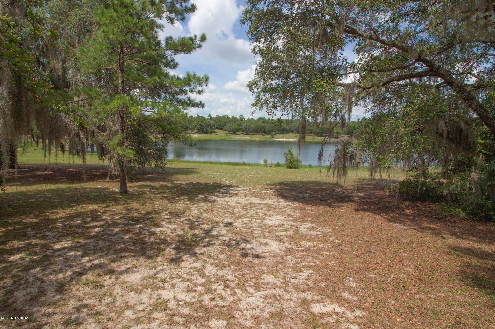 6988 Deer Springs Road Keystone Heights, FL 32656 - Photo 10 of 10 a backyard of a house with lots of green space and lake view in back