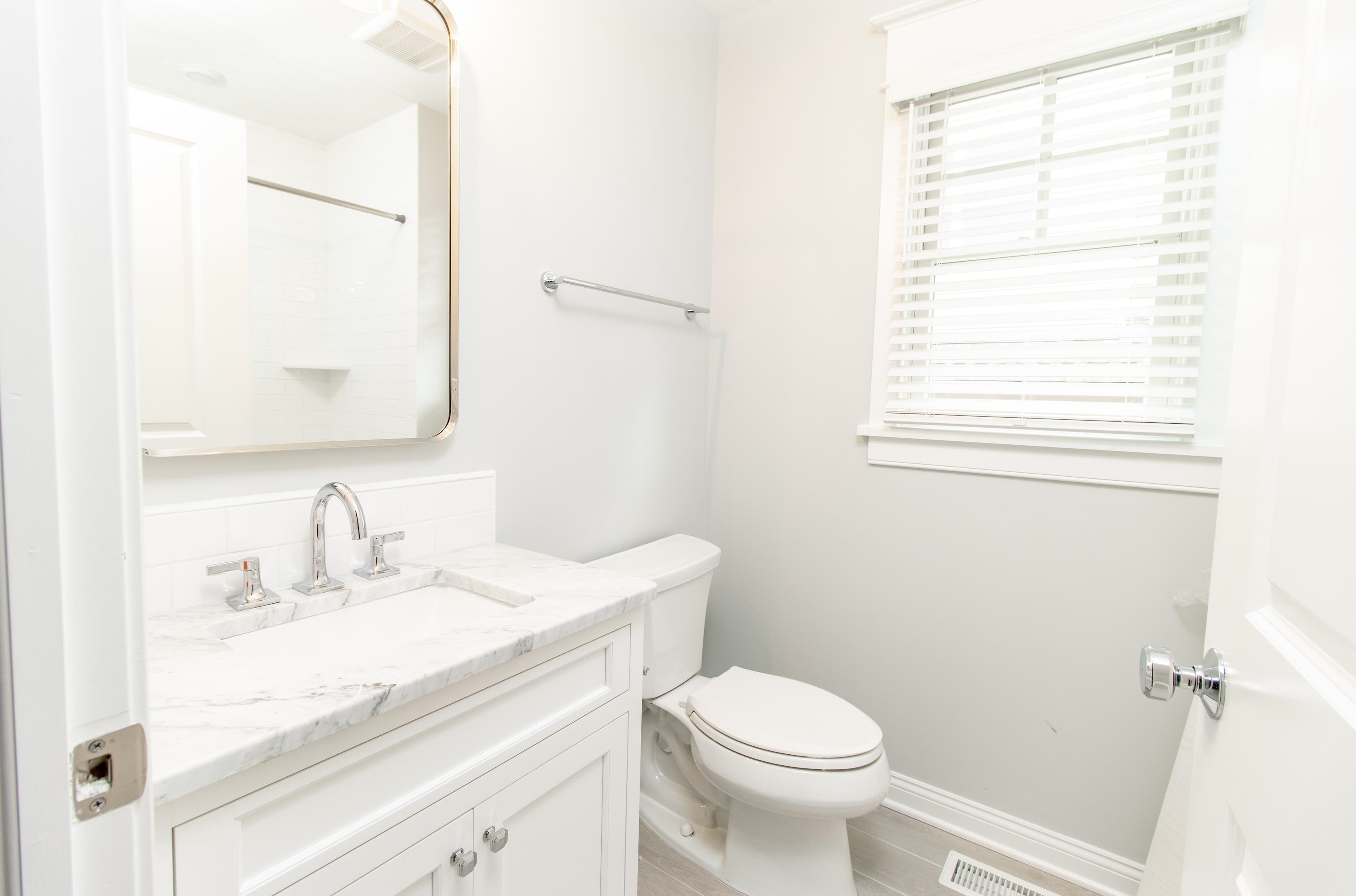 284 33rd, Unit 284 Avalon, NJ 08202 - Photo 6 of 28 a bathroom with a sink a toilet and a mirror