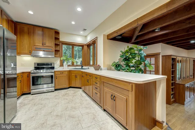 a kitchen with stainless steel appliances sink and large window
