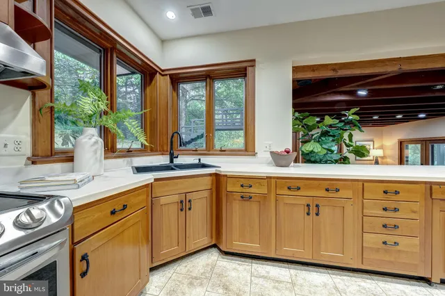 a kitchen with stainless steel appliances granite countertop a sink a stove and cabinets