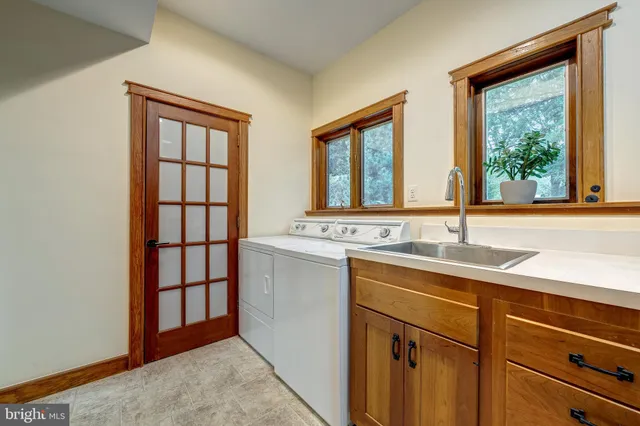 a spacious bedroom with a bed a chandelier and a dresser