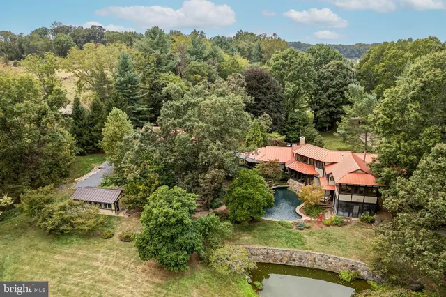 an aerial view of a house with a yard and lake view