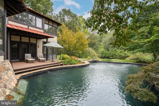 a view of a lake with a house and a yard with plants