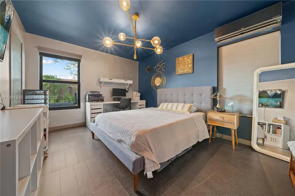 a spacious bedroom with a large bed and a chandelier