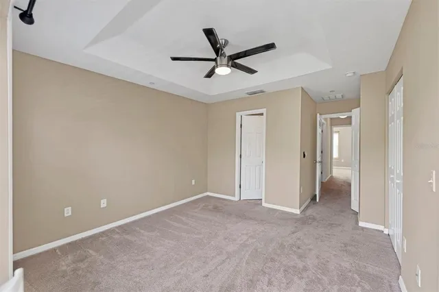 a view of a livingroom with a ceiling fan & window
