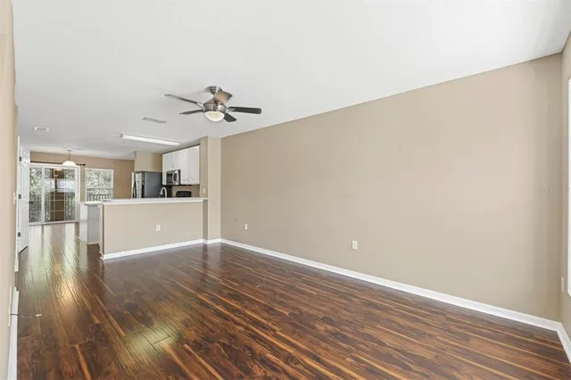 a view of a livingroom with wooden floor and a ceiling fan