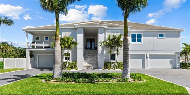 a front view of yellow house with a garden
