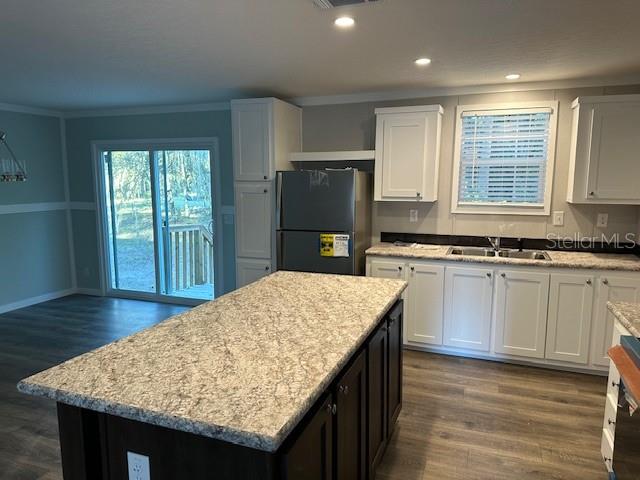 374 Sisco Road Pomona Park, FL 32181 - Photo 27 of 51 a kitchen with granite countertop wooden cabinets a stove top oven a sink and dishwasher with wooden floor