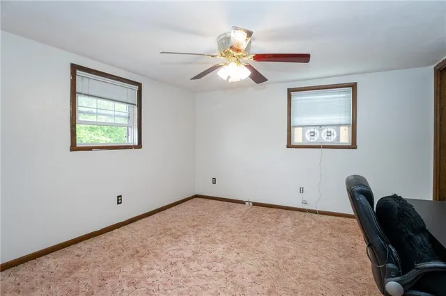 a spacious bedroom with a bed and a ceiling fan