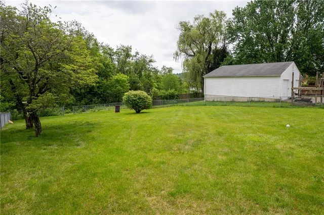 a view of a yard in front of a house with large trees