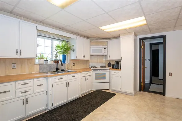 a kitchen with white cabinets and white appliances
