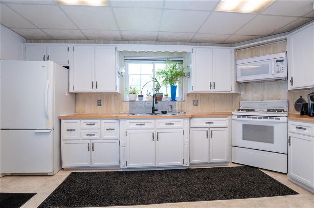 10 North Street Atlasburg, PA 15004 - Photo 6 of 27 a kitchen with granite countertop white cabinets white appliances a sink and a stove
