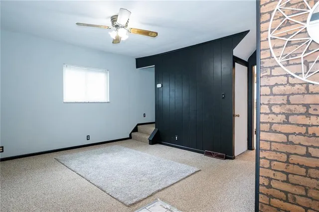 an empty room with closet and a chandelier fan