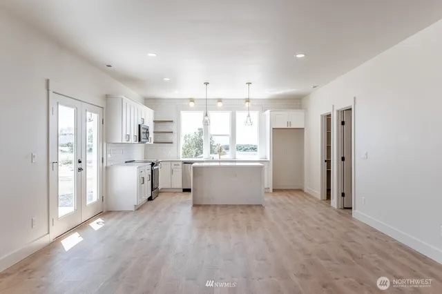 a view of a big room with wooden floor and windows
