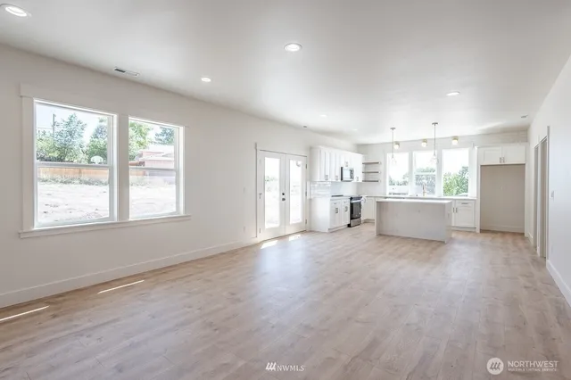 a view of a kitchen with a sink and dishwasher a refrigerator with wooden floor