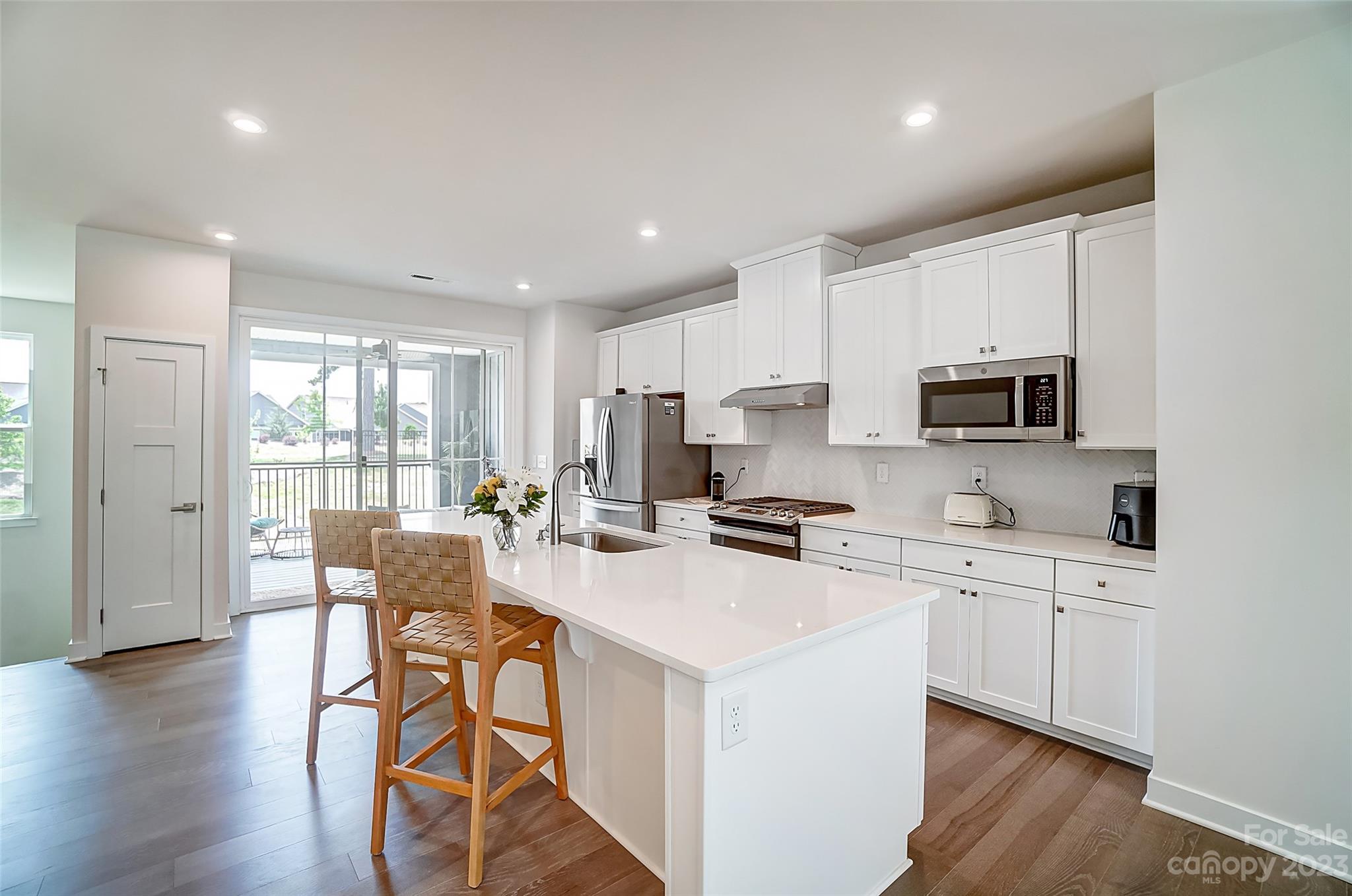 636 Crudent Road Tega Cay, SC 29708 - Photo 12 of 45 a kitchen with stainless steel appliances a stove a sink a refrigerator cabinets and dining table