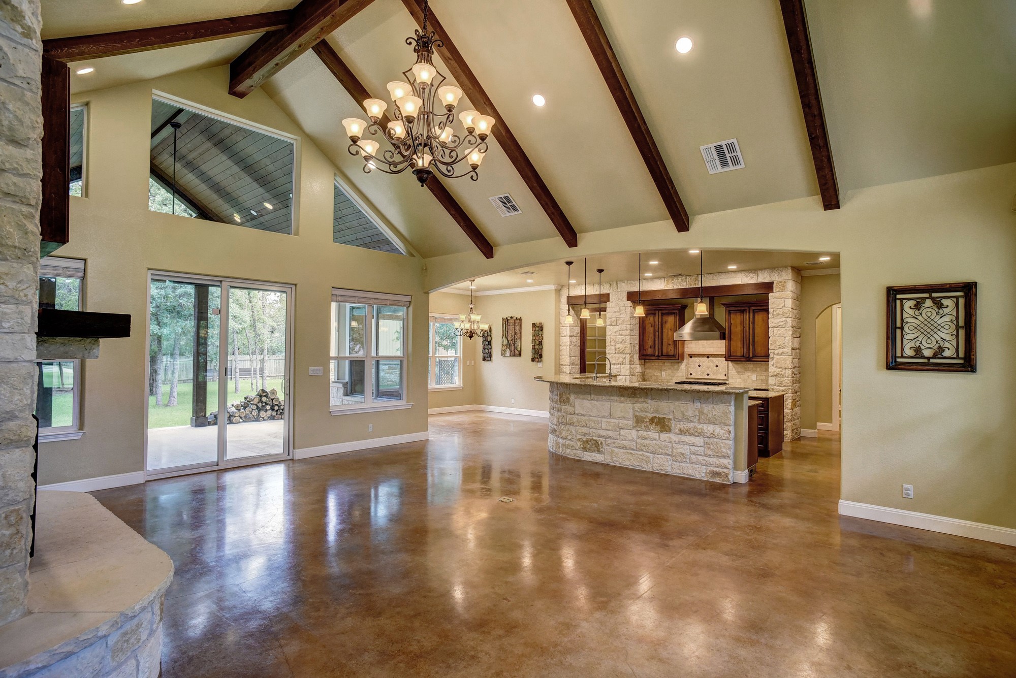 115 Pine Point Cove Elgin, TX 78621 - Photo 4 of 39 Vaulted ceilings with exposed beams define this spacious living area, flowing seamlessly to a well-appointed kitchen.