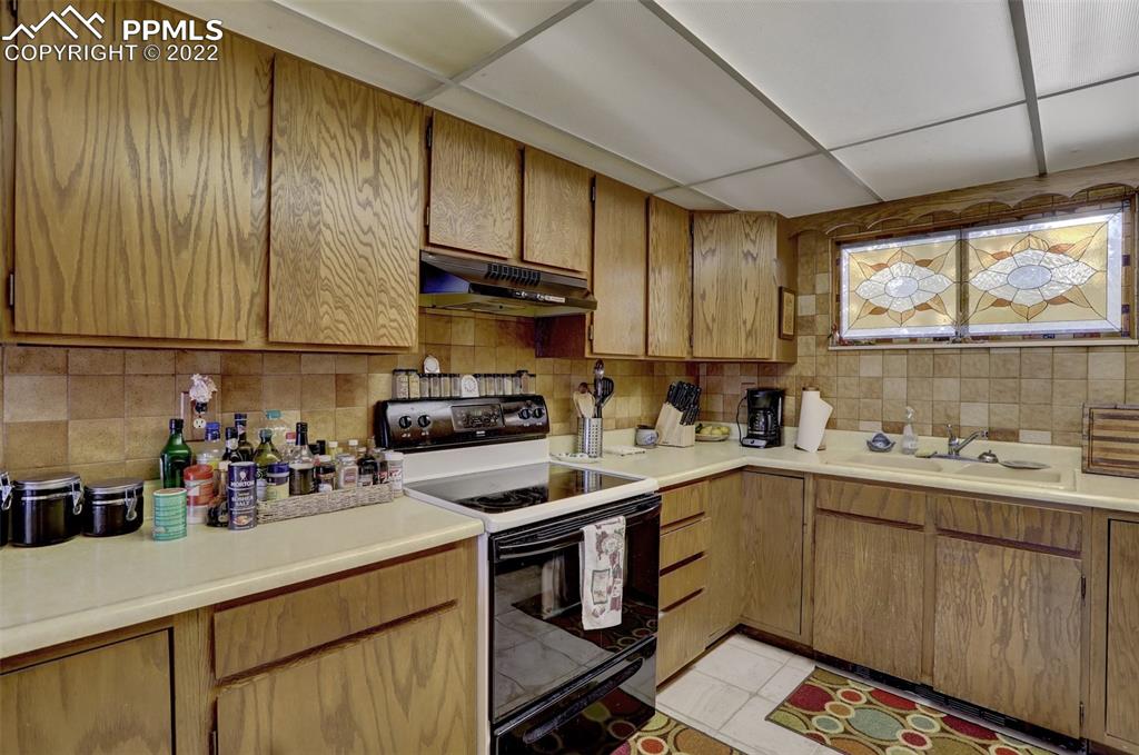 756 Spring Valley Drive Divide, CO 80814 - Photo 16 of 50 a kitchen with a sink a stove cabinets and a window