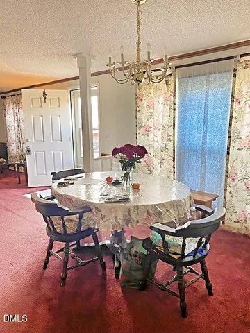 a view of a dining room with furniture and chandelier