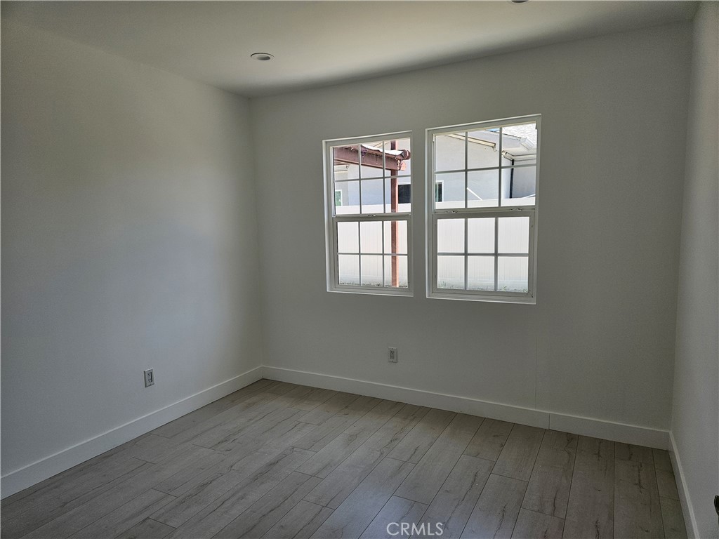 7820 Lindley Avenue Reseda, CA 91335 - Photo 14 of 16 an empty room with wooden floor and windows
