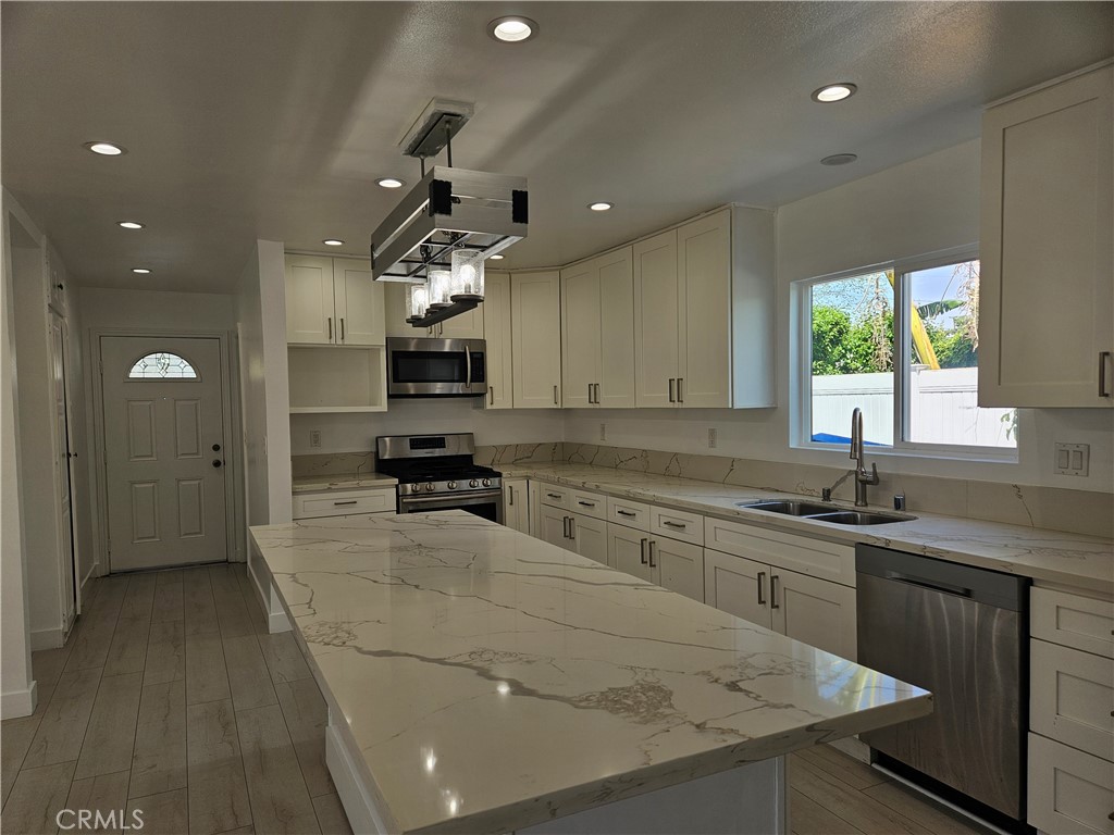 7820 Lindley Avenue Reseda, CA 91335 - Photo 6 of 16 a kitchen with granite countertop a sink stainless steel appliances and cabinets