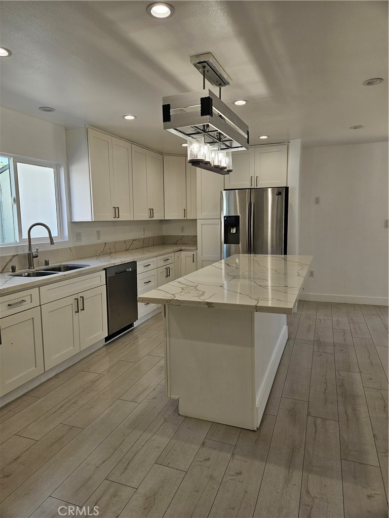 7820 Lindley Avenue Reseda, CA 91335 - Photo 7 of 16 a large kitchen with stainless steel appliances granite countertop a sink and cabinets