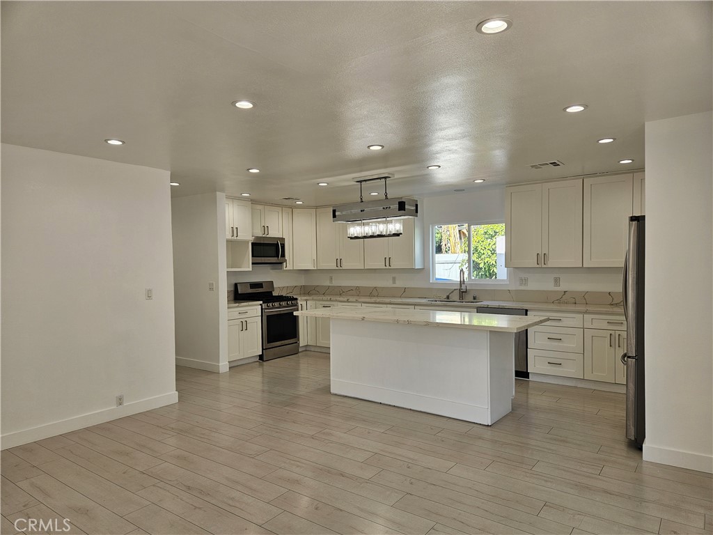 7820 Lindley Avenue Reseda, CA 91335 - Photo 8 of 16 a kitchen with white cabinets and counter top space