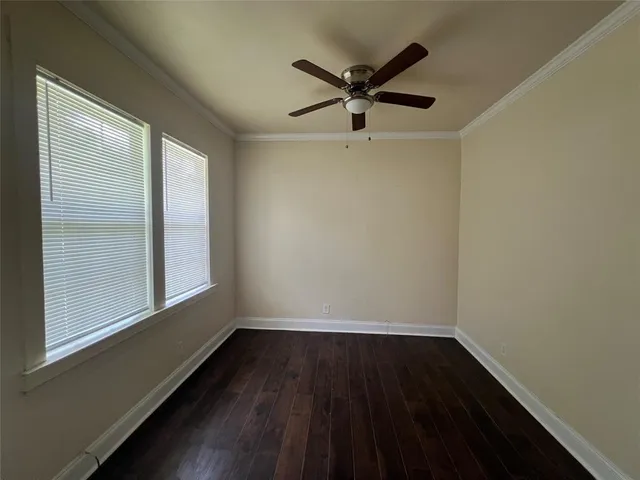 a view of a big room with wooden floor and windows