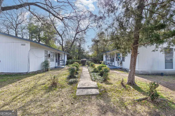 a view of a house with backyard and sitting area