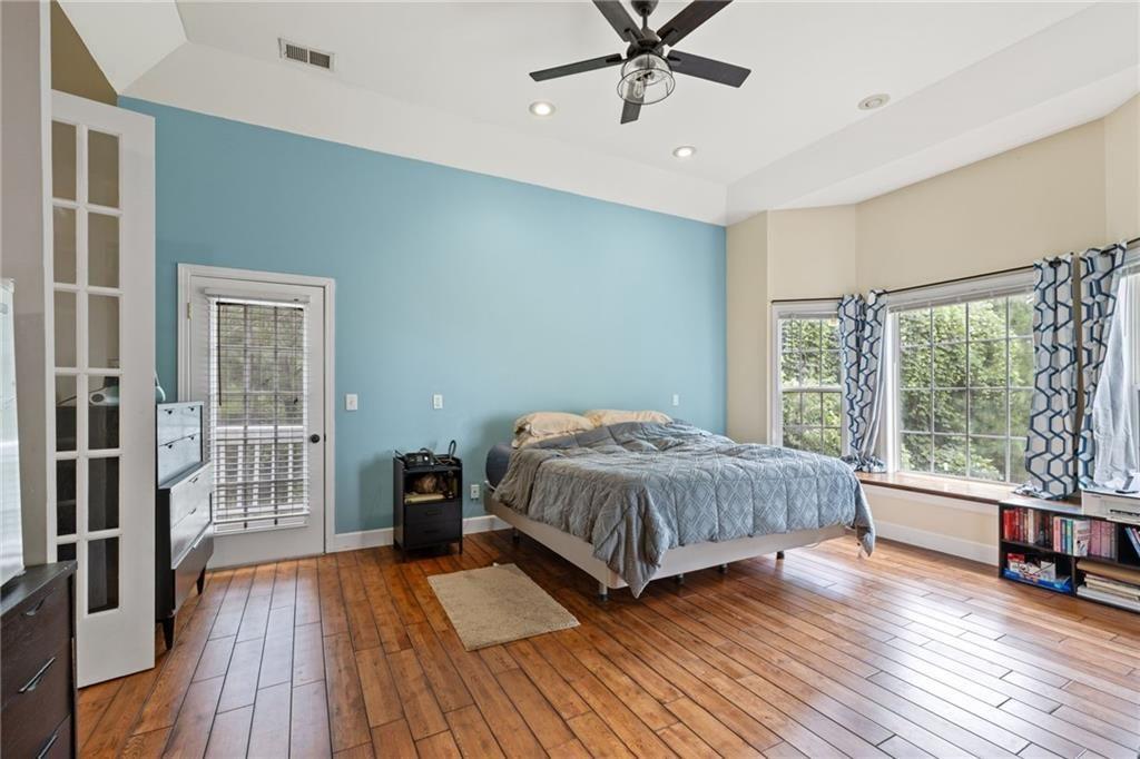 166 Freedom Lane Commerce, GA 30530 - Photo 16 of 23 a bedroom with a large bed and wooden floor