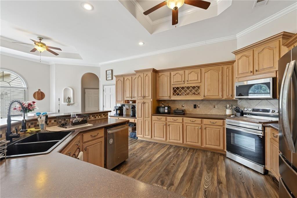 166 Freedom Lane Commerce, GA 30530 - Photo 5 of 23 a kitchen with stainless steel appliances granite countertop a stove a sink dishwasher and a refrigerator with wooden floor
