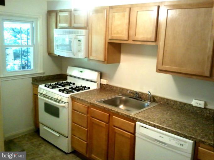 790 Charing Cross Road Baltimore, MD 21229 - Photo 13 of 14 a kitchen with a sink and a stove next to a window