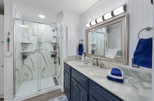 a bedroom with a bed and a flat tv screen on dresser